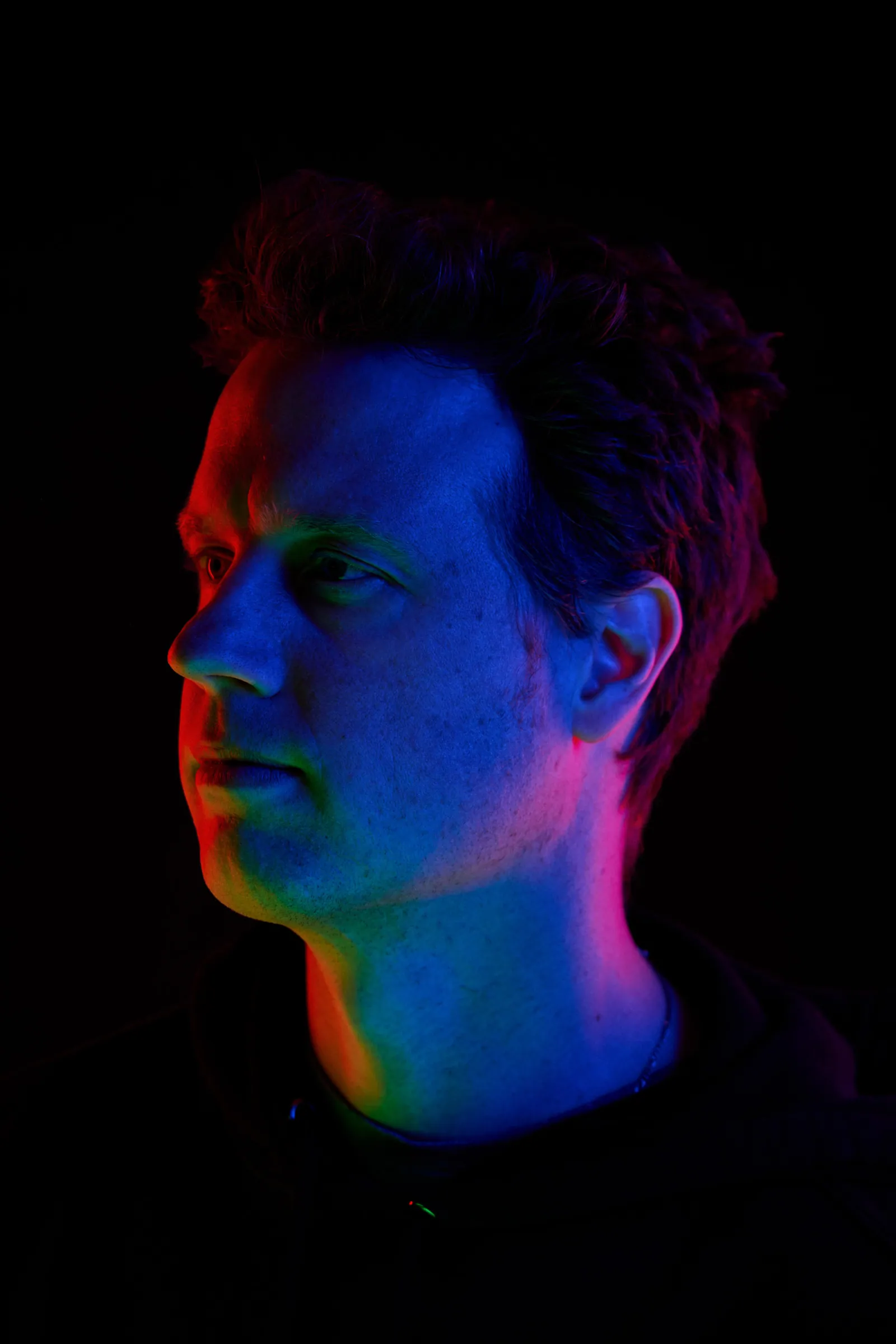portrait of a man with colorful lights on his face